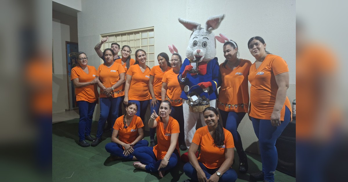 Eles estão reunidos em um ambiente interno, que parece ser uma área comum ou um corredor amplo da escola, com piso de cor verde e paredes claras. Tema - limites na educação infantil na Escola Aclive, Setor Vila Rosa, Goiânia, Goiás.