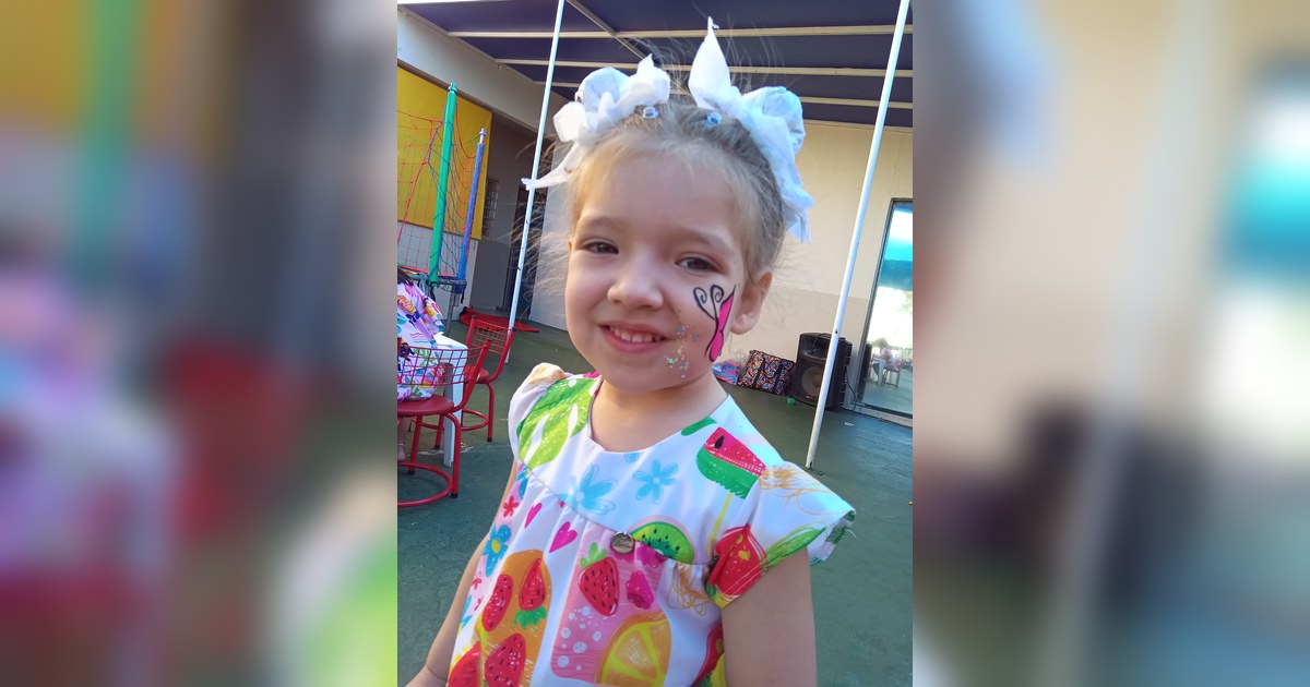 A imagem frontal mostra uma criança, aparentemente uma menina de idade pré-escolar, sorrindo para a câmera. Tema - projetos pedagógicos educação infantil na Escola Aclive, Setor Vila Rosa, Goiânia, Goiás.