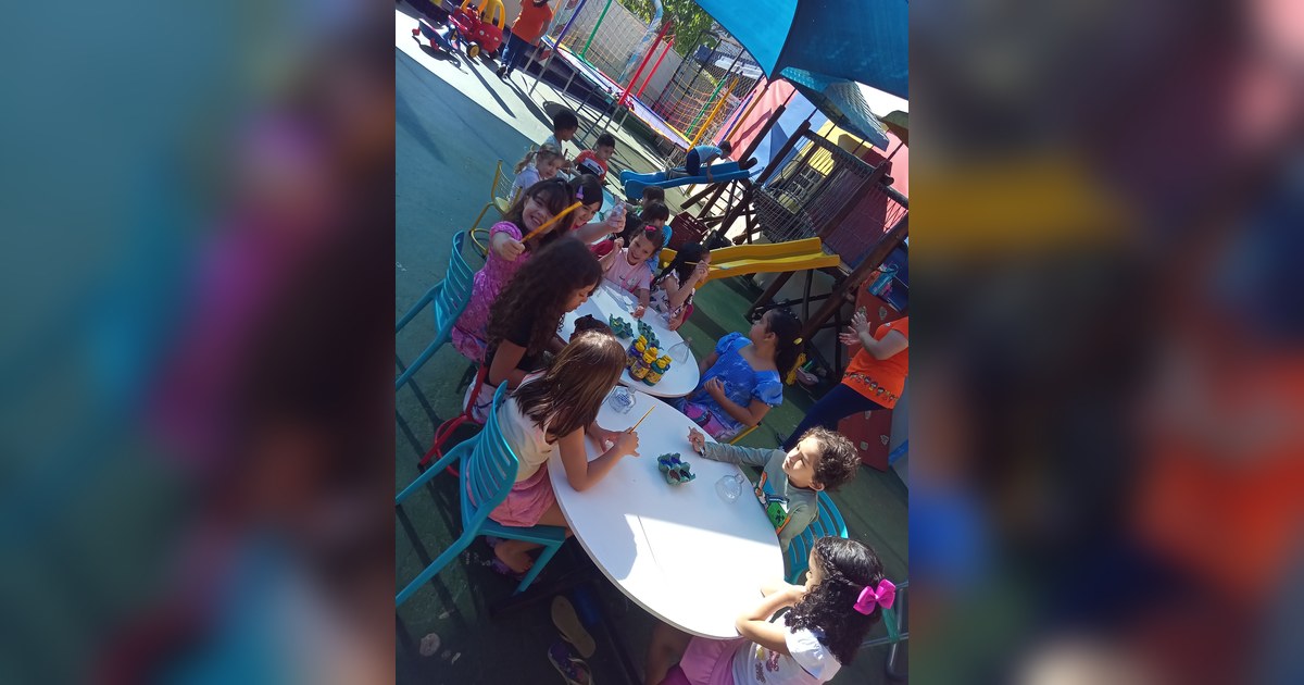Cerca de quinze crianças de idade pré-escolar ou infantil estão na cena, a maioria sentada. Tema - checklist escola infantil na Escola Aclive, Setor Vila Rosa, Goiânia, Goiás.